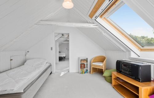 a attic bedroom with a bed and a window at 4 Bedroom Gorgeous Home In Varde in Varde