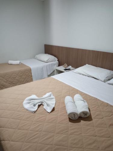 a hotel room with two beds with towels on them at Pousada Boi Bumba Tambau in João Pessoa