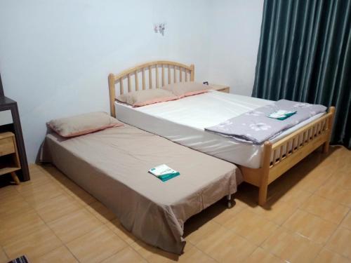 two beds sitting next to each other in a room at pen kyu house1 in Kota Samarahan