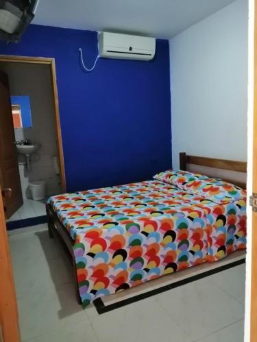 a bed with a colorful comforter in a room at Hotel Rio Grande 2 in El Banco