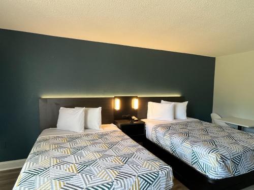 two beds sitting next to each other in a hotel room at Studio 6 Hammond, LA I12 I55 in Hammond