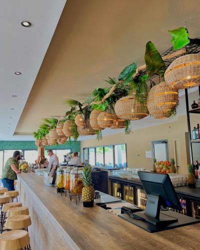 un bar dans un restaurant avec des personnes préparant des repas dans l'établissement Mobil Home XXL 4 chambres - Camping Les Tropiques, à Torreilles