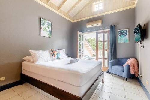 a bedroom with a large bed and a blue chair at Idilio Escape in Ocho Rios
