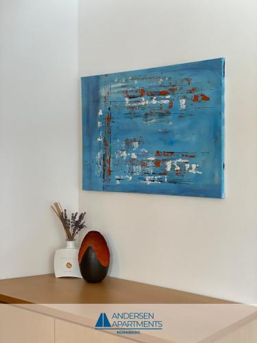 a painting hanging on a wall above a shelf at Toplage für Beruf & Freizeit in Nürnberg - Andersen Apartments in Nürnberg