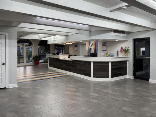 a large lobby with a counter in a building at Studio 6 Tallahassee, FL North Monroe in Tallahassee