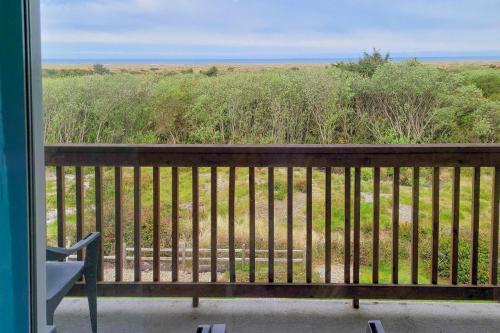 a balcony with a bench and a view of a field at Sunset Dunes in Ocean Shores