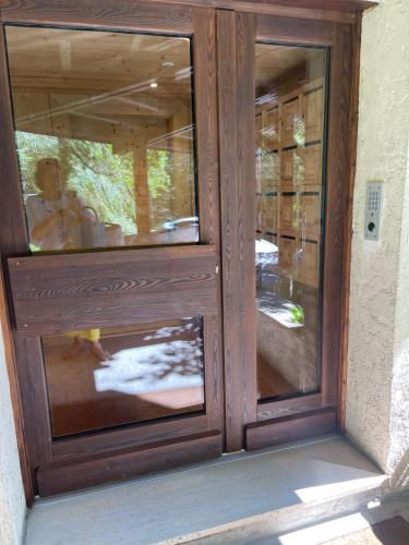 une porte en bois avec deux fenêtres en verre sur un bâtiment dans l'établissement studio 1 personne megeve heidi5, à Megève