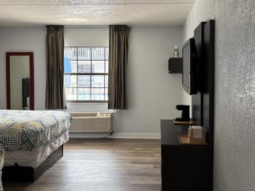 a hotel room with a bed and a window at Studio 6 Tallahassee, FL North Monroe in Tallahassee