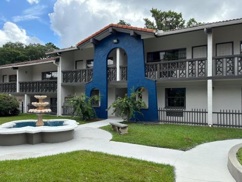 a blue building with a fountain in the yard at Studio 6 Tallahassee, FL North Monroe in Tallahassee