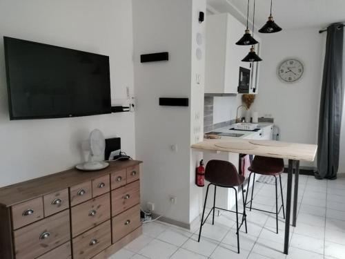 Il comprend une cuisine avec une table et une télévision murale. dans l'établissement Studio tout confort centre-ville, à Tarbes