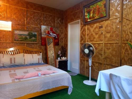 a bedroom with a bed and a fan in it at Hidden Tourist Inn in Abu