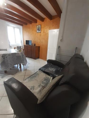 un salon avec un canapé noir et une table dans l'établissement Au coeur de la campagne - Gite non loins d'Annecy- à 17 min d'Annecy - Tout prêt d'Aix les Bains, à Saint-Girod