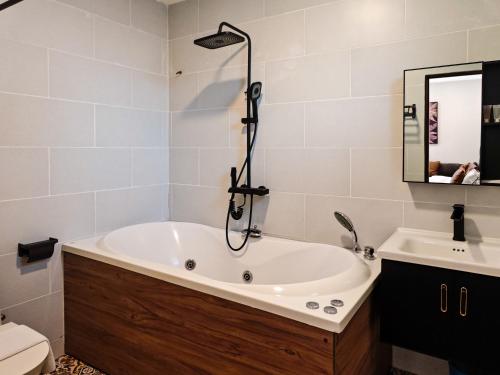 un bagno con vasca e lavandino di Mulyo Hotel a Port Dickson