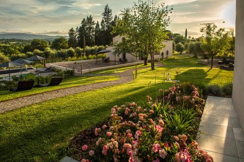 a garden with pink flowers in the grass at Borgo Elissa Country Relais in Certaldo