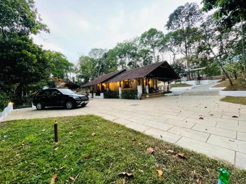 a car parked in front of a building at Drey at Druv Dakshin Farm Resort in Padinjarathara