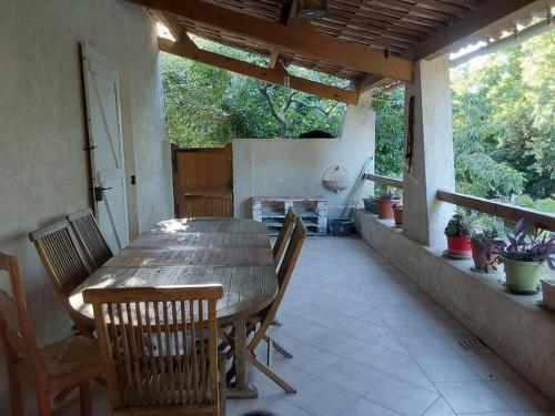a wooden table and chairs on a patio at LE HAVRE DE PAIX in Peypin