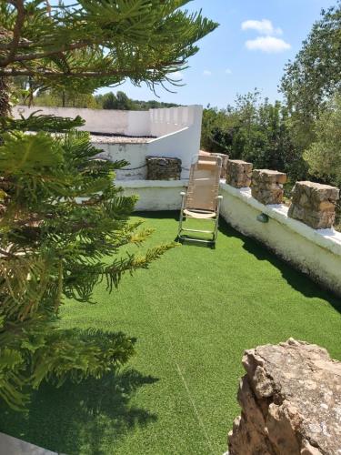a lounge chair sitting on the grass in a yard at EL CASTELLET in Traiguera