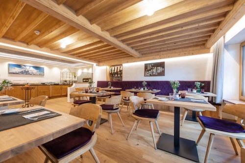 a restaurant with wooden ceilings and tables and chairs at Bruggerhof in Fulpmes