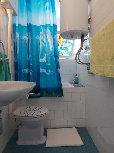 un bagno con lavandino, water e tenda da doccia di Holiday home by the sea a Primošten
