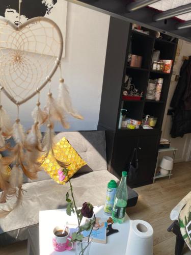 un salon avec une table et un lustre en forme de cœur dans l'établissement Petit Nid à Paris, à Paris