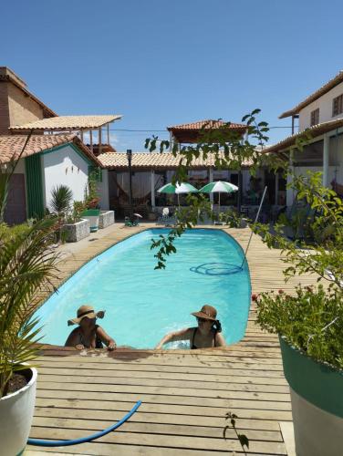 two people in a swimming pool at a resort at Pousada Tycoz Flor do mar in Galinhos