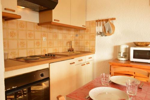 une cuisine avec une table avec deux assiettes dessus dans l'établissement Appartement 2 pièces 4 couchages ARGELES SUR MER AR320-011, à Argelès-sur-Mer