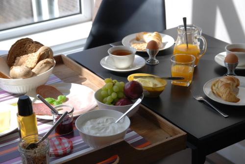 a table with a tray of breakfast foods on it at Bed & Breakfast Obrechtstraat in The Hague
