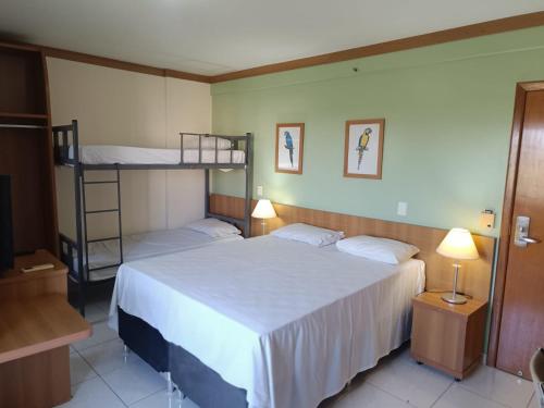 a bedroom with a bed and bunk beds in it at Apto Golden Dolphin in Caldas Novas
