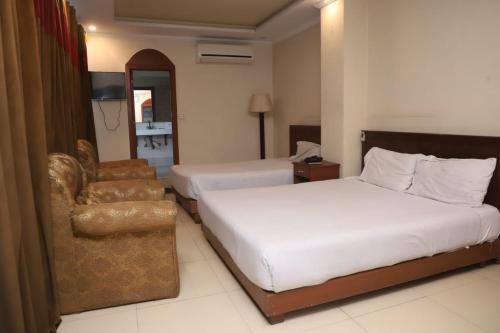 a hotel room with a bed and a chair at PAK Heritage Hotel in Lahore