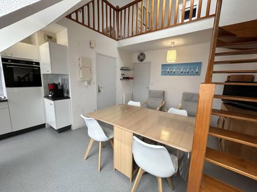 une cuisine et une salle à manger avec une table et des chaises en bois dans l'établissement 502 - Appartement T3, avec vue sur sur la mer., à Erquy