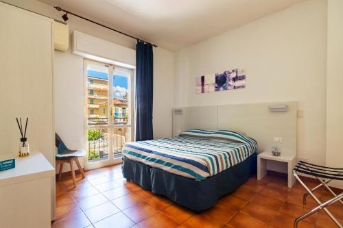 sypialnia z łóżkiem i oknem w obiekcie Piccolo hotel le Palme w mieście San Bartolomeo al Mare