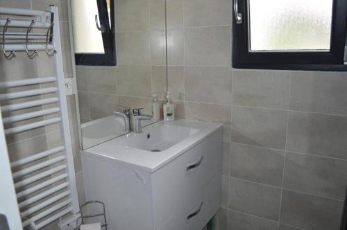une salle de bain avec un lavabo blanc et une fenêtre dans l'établissement Appart 2 pièces 4 couchages ARGELES SUR MER AR055-103, à Argelès-sur-Mer