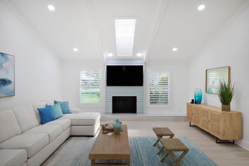 a living room with a white couch and a fireplace at Sea Glass Villa- Executive Pool Home on Golf Course in Sanibel