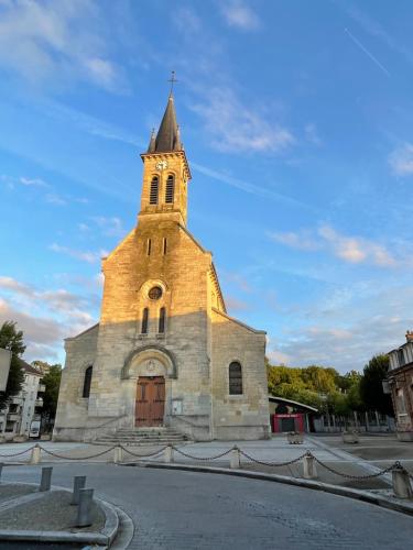 an old church with a tower with a cross on it at Le cocon du centre ville in Torcy