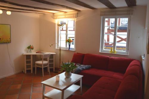 a living room with a red couch and a table at Ferienhaus Old Winery in Briedel