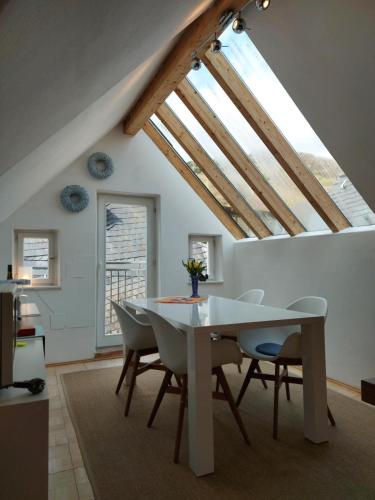 a dining room with a white table and chairs at Ferienhaus Old Winery in Briedel