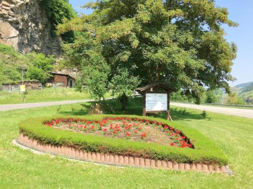 a flower garden with a sign in the grass at Ferienhaus Old Winery in Briedel