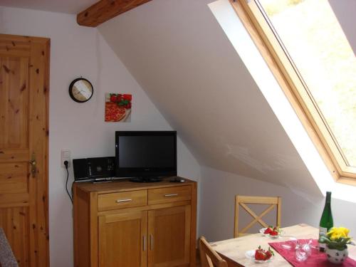 een kamer met een eettafel en een tv op een kast bij Mosel Ferienhaus Kleine Merle in Zell an der Mosel