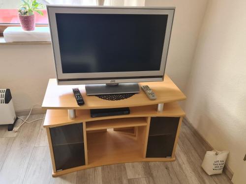 a tv sitting on a wooden stand with a television at Haus Kurtrier in Merl