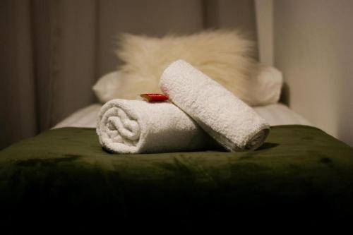 a pile of towels sitting on top of a bed at Stylish Madison Apartment with Balcony - FREE Car Parking - Hemel Hempstead Town Centre in Hemel Hempstead