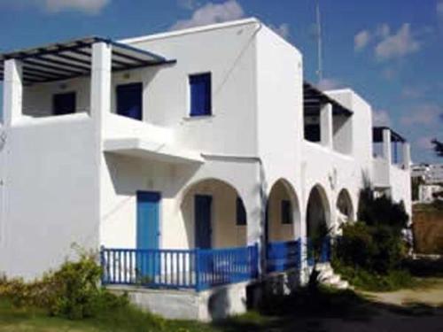 una casa blanca con una valla azul delante de ella en Studios Parian Blu en Logaras