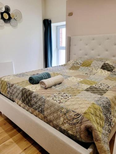 - un lit avec une couette et 2 oreillers dans l'établissement Charmante maison totalement rénovée, à Saint-Géron