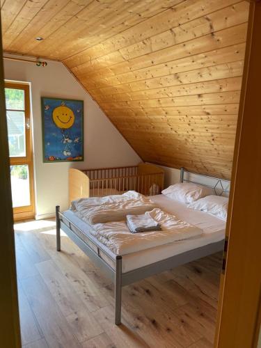 a bed in a room with a wooden ceiling at Das gelbe Landhaus in Tellig