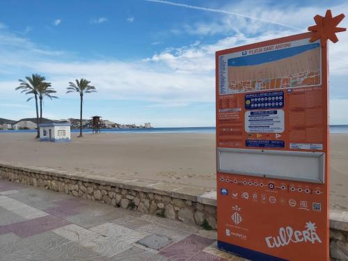 a sign on the beach with the beach in the background at Amazing beach apartment in Cullera