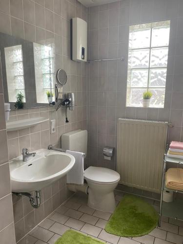 a bathroom with a white sink and a toilet at Ferienwohnung 2 Am Petersberg in Neef
