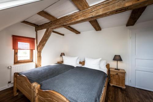 a bedroom with a bed in a room with wooden ceilings at GH Maisonette Studio Whg 45 in Bastorf