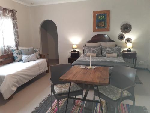 a bedroom with two beds and a wooden table at Kleinfontein in Clanwilliam