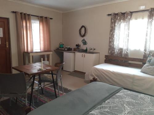 a bedroom with a bed and a table and a kitchen at Kleinfontein in Clanwilliam