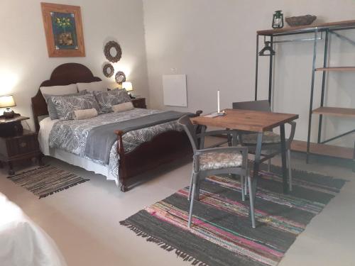 a bedroom with a bed and a table and a desk at Kleinfontein in Clanwilliam