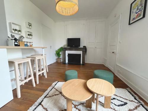 - un salon avec deux tables et des chaises en bois dans l'établissement Le Cocon Angevin, à Angers